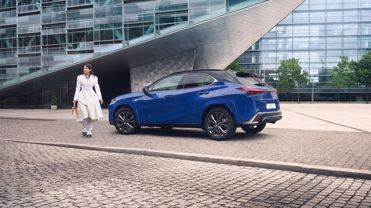 Vrouw naast een blauwe Lexus UX 300h