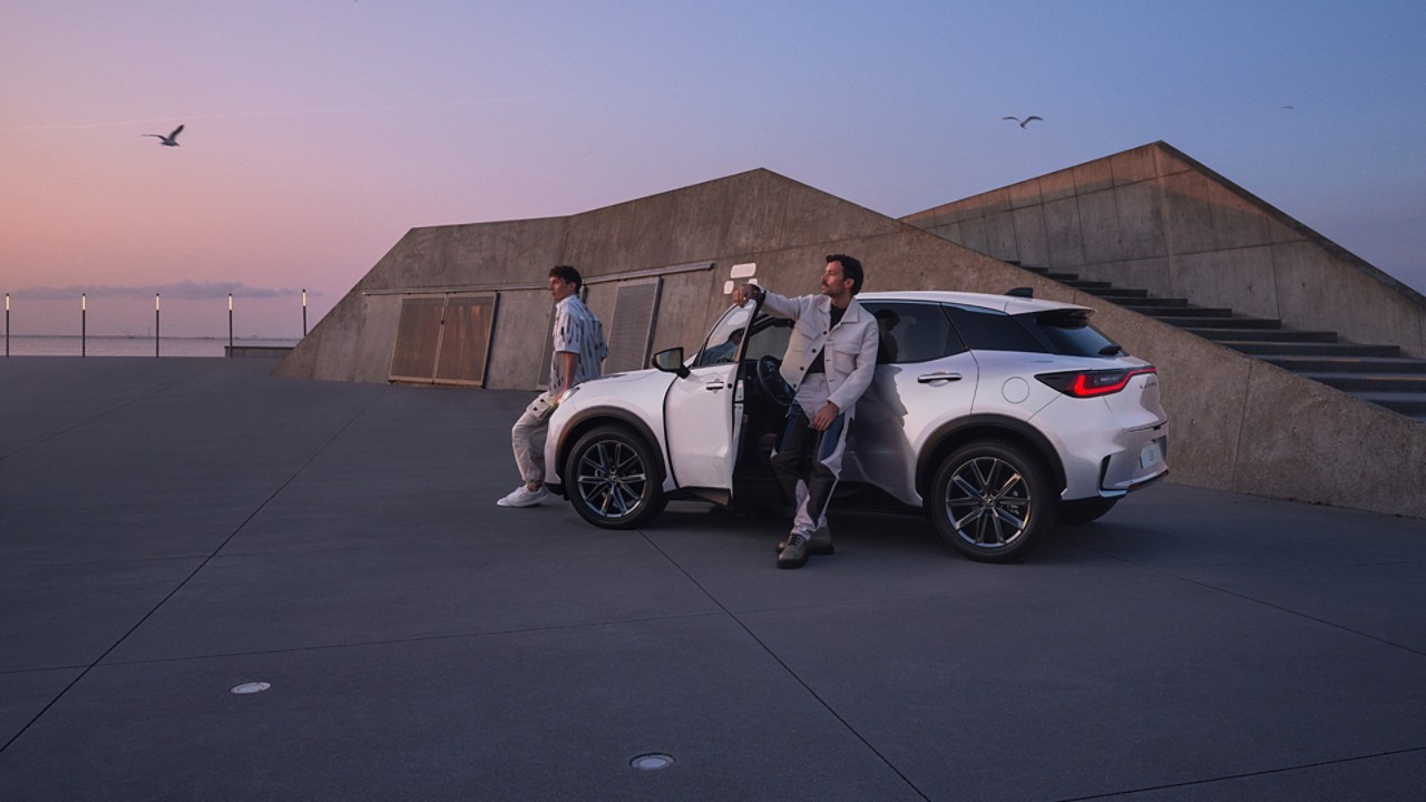 Drie personen rondom een witte Lexus LBX