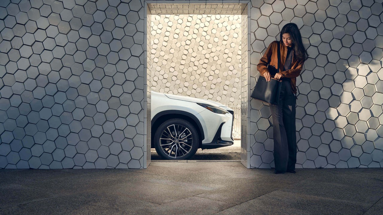 Vrouw naast een witte Lexus kijkt in haar tas