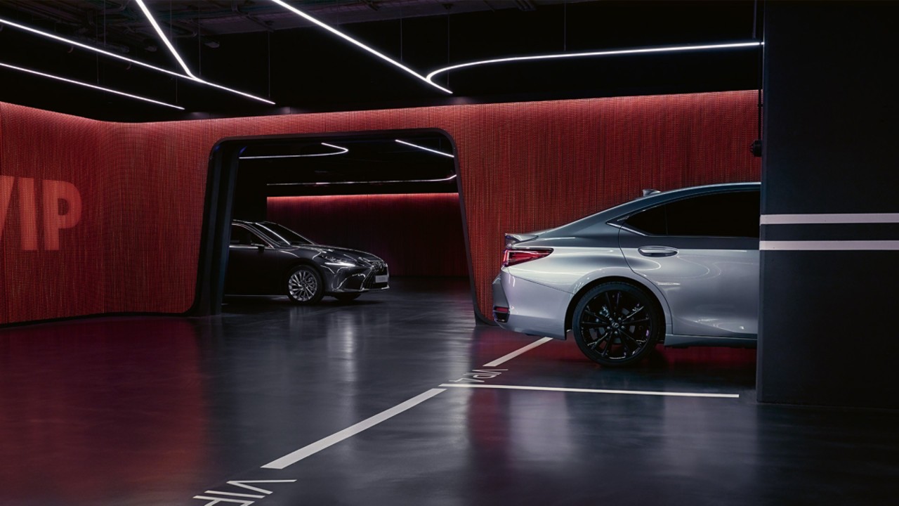 Een zilveren en zwarte Lexus ES geparkeerd in een verlichte garage 