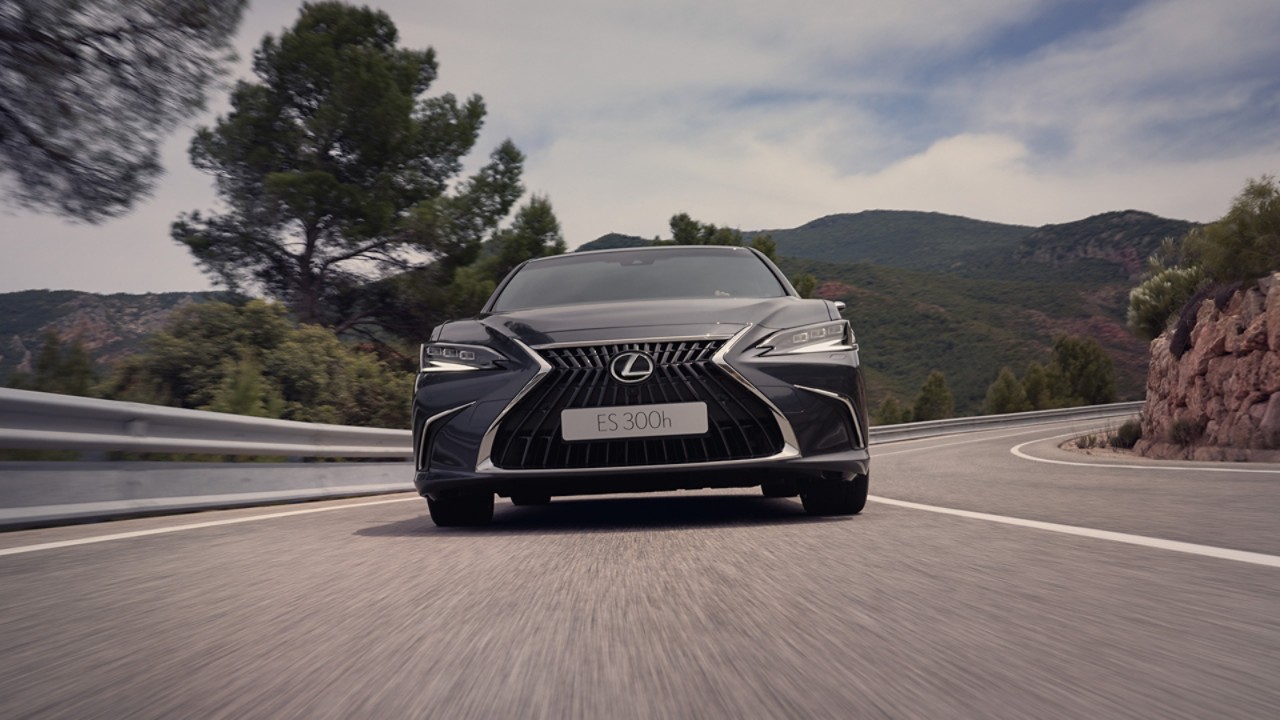 Vooraanzicht van een Lexus ES bij het verlaten van een bocht in de weg