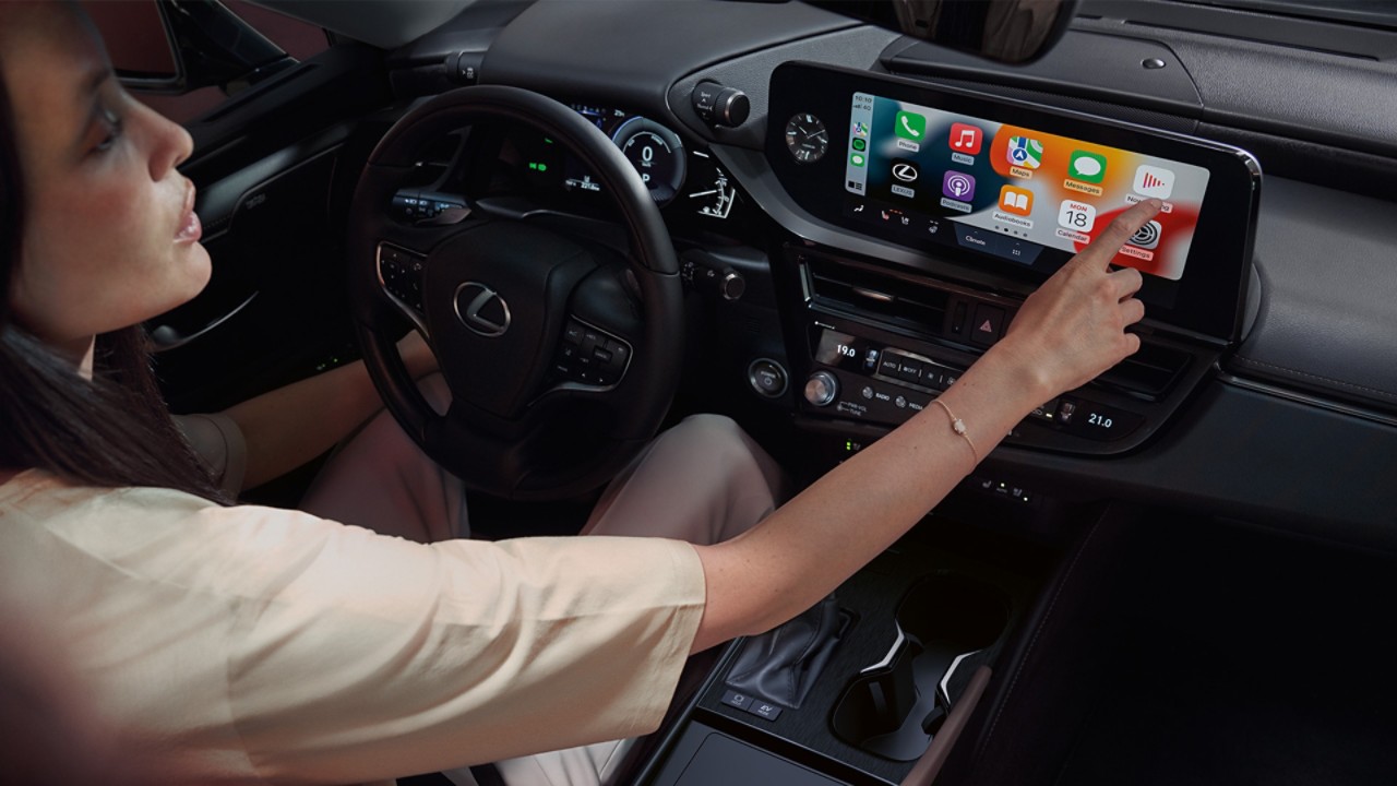 Een vrouw gebruikt het multimediascherm in de Lexus ES