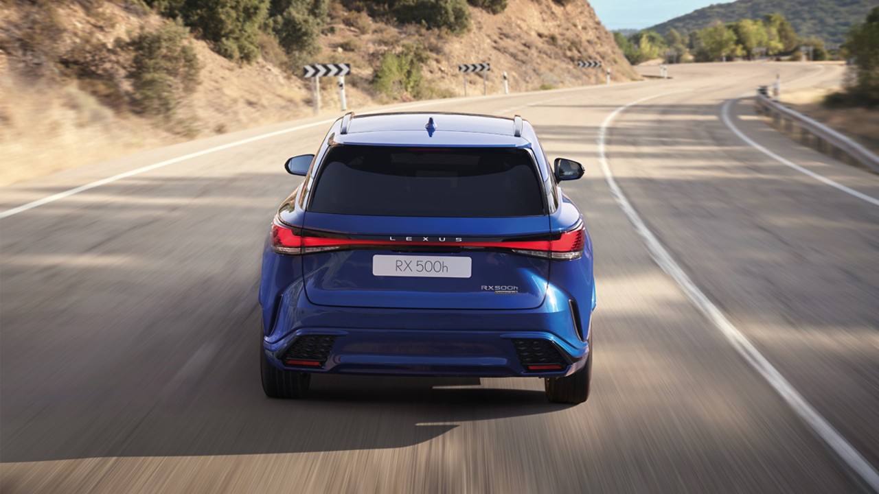 De achterzijde van een rijdende blauwe Lexus RX