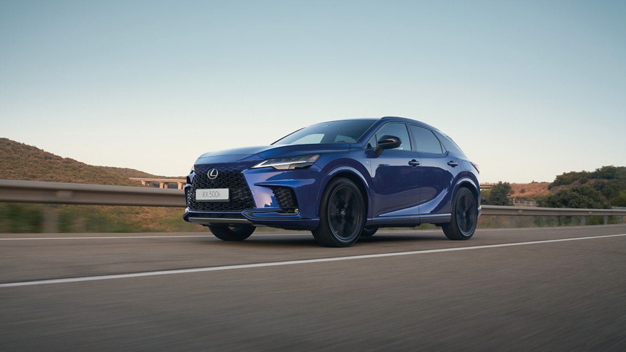 Een rijdende blauwe Lexus RX met zwartmetalen velgen