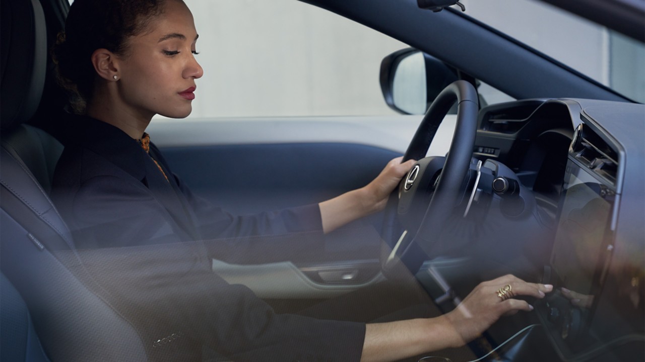 Een vrouw zit in een Lexus RZ 450e