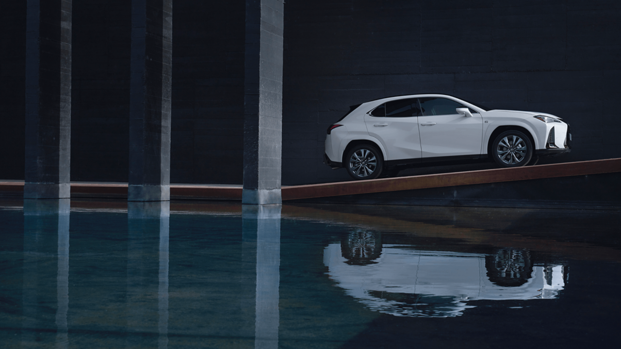 Zijaanzicht van een geparkeerde Lexus UX naast water