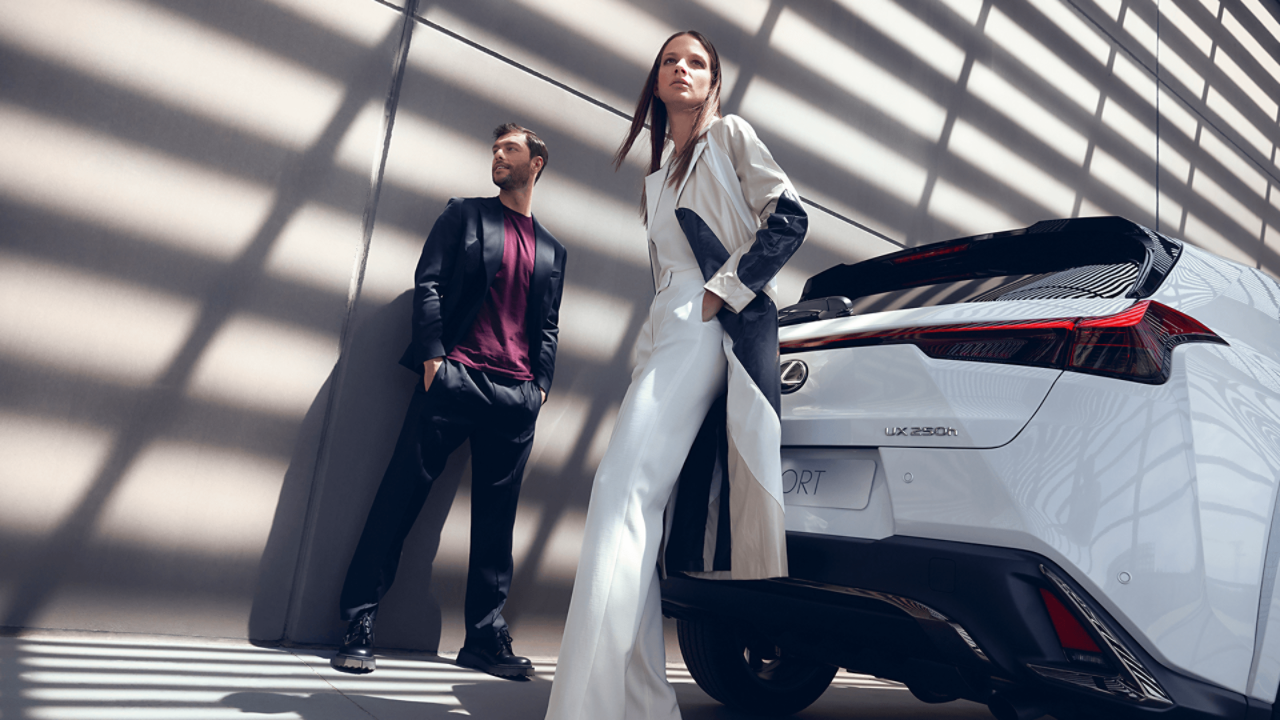  Een man en vrouw staan naast een Lexus UX F Sport