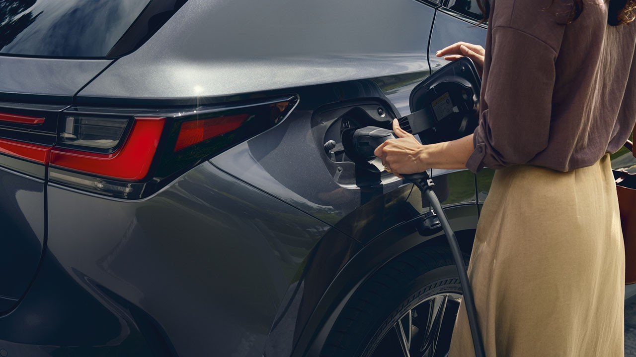 Een vrouw gebruikt een thuislader in een Lexus NX 