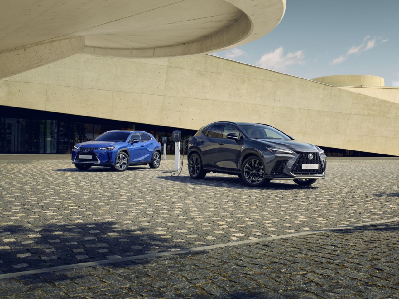Een Lexus UX 300e en Lexus NX aangesloten op een laadpaal 