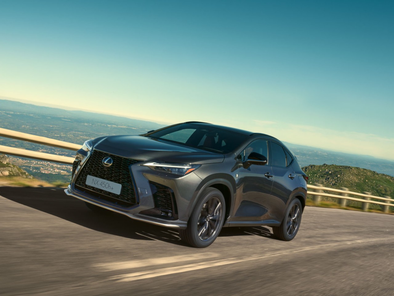 Een Lexus NX 450h+ rijdend op een kustweg