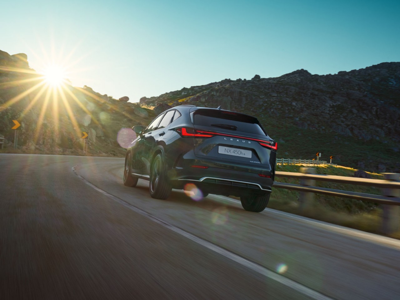 Een achteraanzicht van de Lexus NX 450h+ rijdend 