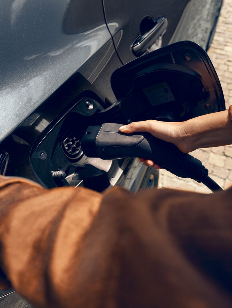 Een man sluit een oplader aan op een Lexus NX