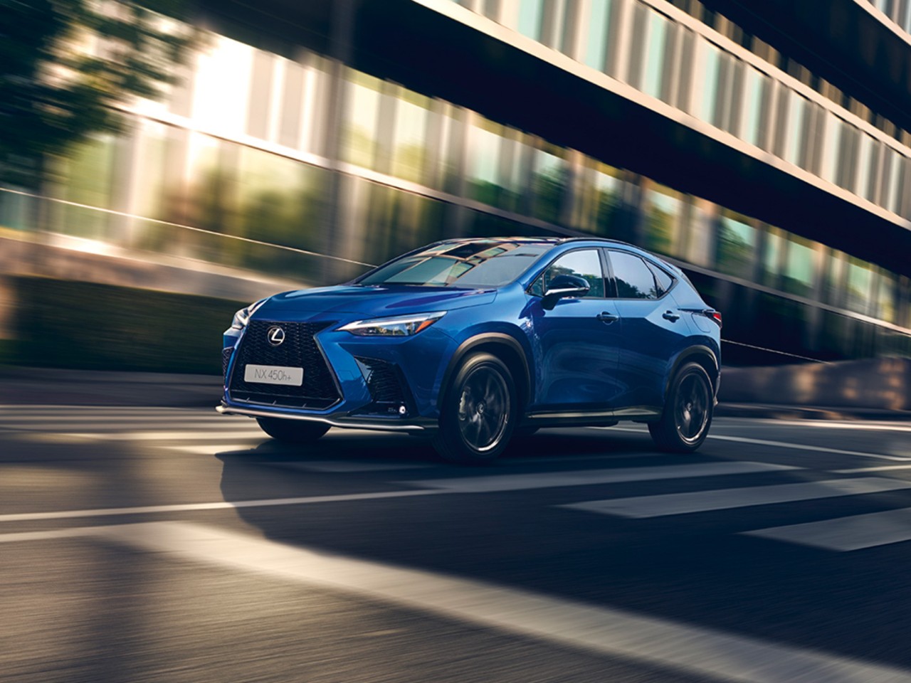 Blauwe Lexus NX 450h+ rijdend in de stad 