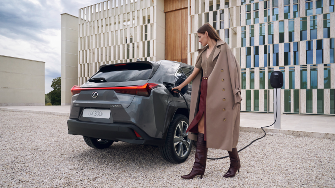 Een persoon die een stopcontact in een Lexus UX 300e steekt