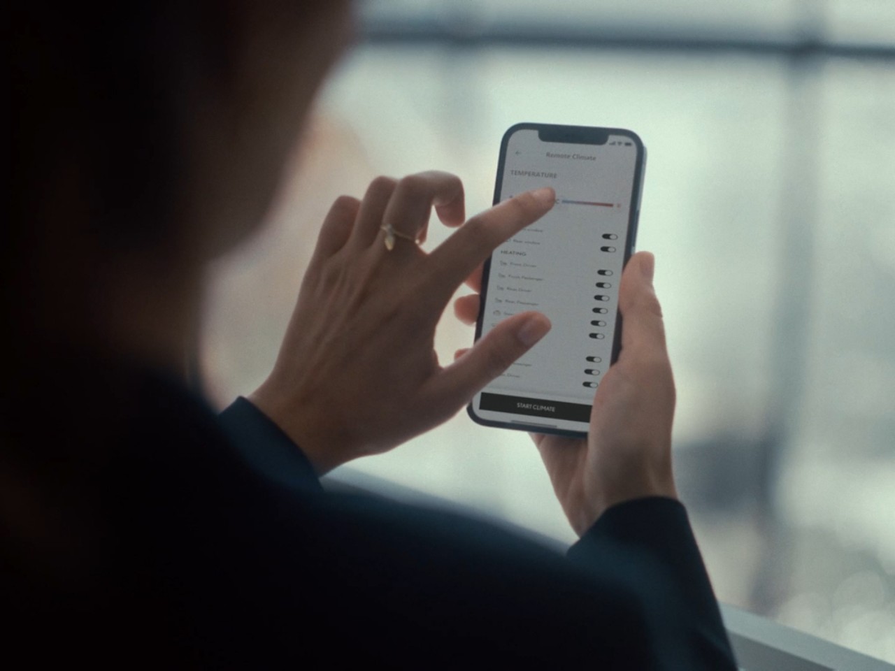 Een persoon die een mobiele telefoon gebruikt om toegang te krijgen tot de Lexus Link+ app